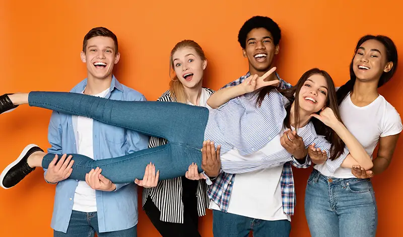 Happy kids holding another child in their arms